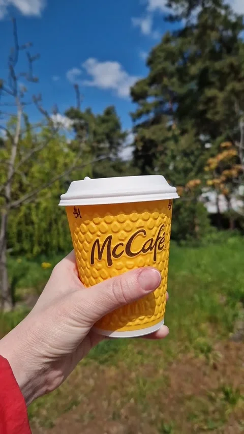 Takeaway coffee from McDonald's on a sunny spring day Stock-Footage 334127828