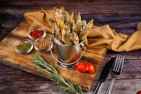 Takeaway: fried small fish served on an oak wood background, close-up Stock Photos