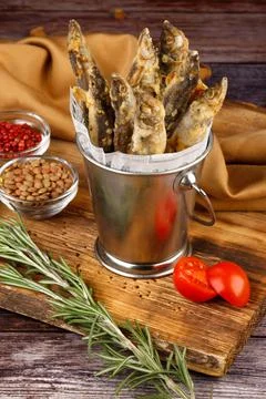 Takeaway: fried small fish served on an oak wood background, close-up Stock Photos