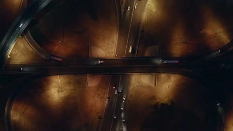 Takeoff up over large roundabout or road transport junction at night with car Stock Footage 140942807