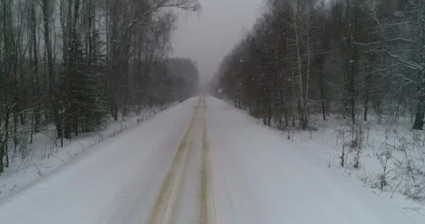 Takeoff over the winter forest road, with active snowfall Stock Footage 147678315