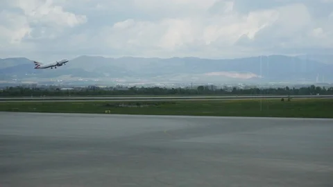Takeoff of the plane against the background of the runway and mountains Stock Footage 90100645