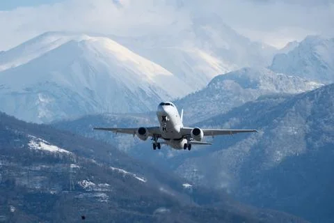 Takeoff with Stunning Mountain Backdrop. Stock Photos