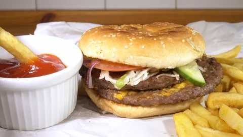 Takeout beefburger and fries / chips with one being dipped into tomato sauce. Vídeos de archivo 107158980