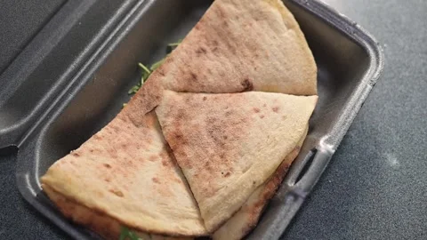 A takeout container opens to reveal freshly made flatbread inside. Focaccia Stock Footage 339005432