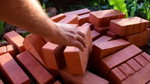 Takes bricks from a pile Stock Footage 117473174