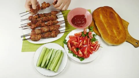 Takes hands and dunks the meat in the sauce.A view of the table top. Stock-Footage 131071465