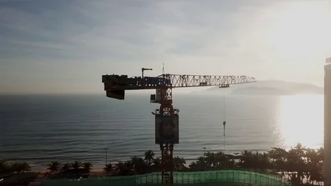 Takes tower cranes at a construction site overlooking the sea Vídeos de archivo 124914432