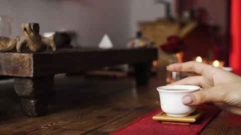 Takes a white mug of tea from the table Stock Footage 139331505