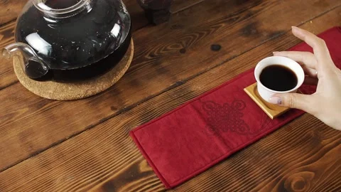 Takes a white mug of tea from the table Stock Footage 139331516