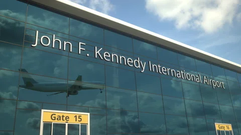 Taking off airplane reflecting in the modern windows with John F. Kennedy Stock Footage 154064238