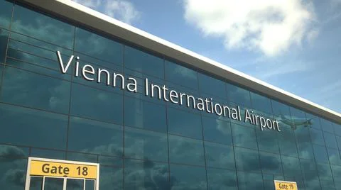 Taking off airplane reflecting in the modern windows with Vienna International Ilustración de archivo