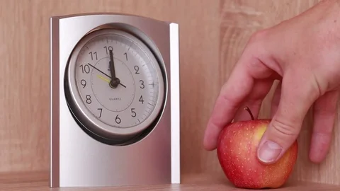Taking an apple near the clock 動画素材 83030047