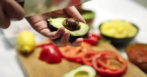 Taking the avocado nut out with a knife in slow motion Stock Footage 61535381