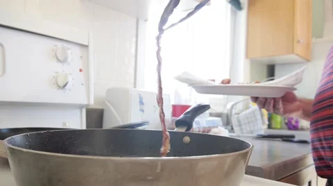 Taking bacon strip out of frying pan and placing on plate with tongs Stock Footage 68655865