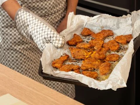 Taking baked breaded cutlets out of the oven Stock Photos