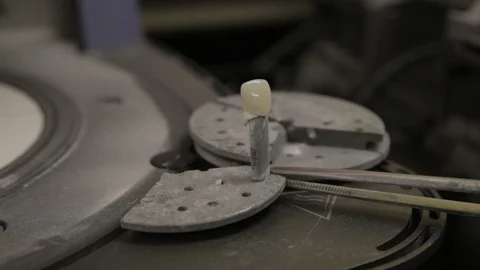 Taking a Baked Front Dental Tooth Crown Out of the Oven to Cool Stock Footage 106162935