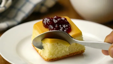 Taking a bite of cake topping with jam on white ceramic plate. 스톡 동영상 147902037