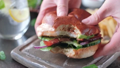 Taking a bite from Halloumi cheese Burger. vegetarian food 스톡 동영상 150953032