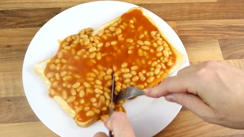 Taking A Bite With A knife And Folk Of Freshly Made Beans On Toast 스톡 동영상 136120444