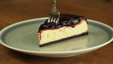 Taking bite of Lemon raspberry cheesecake with fork. Stock Footage 141898661