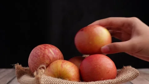 Taking a bite out of an apple on black background Stock Footage 275872434