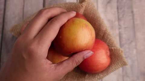 Taking a bite out of an apple on table Stock Footage 275872398