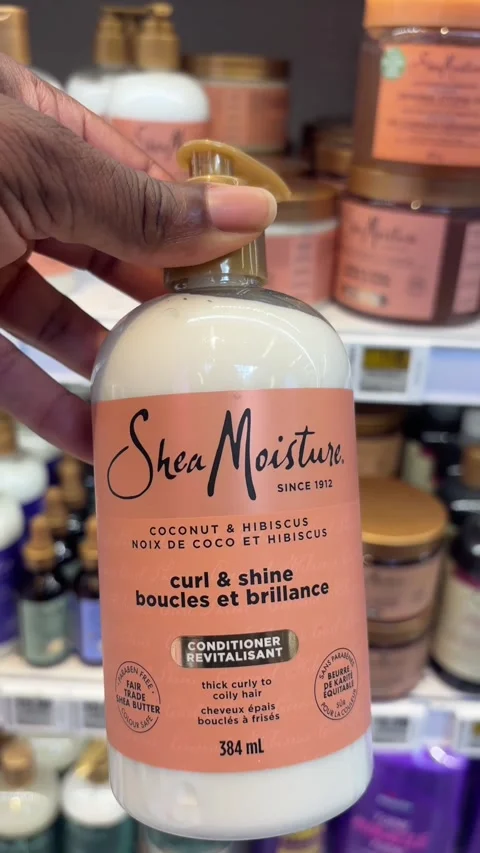 Taking a bottle of Shea Moisture conditioner from a store shelf Stock Footage 334580433