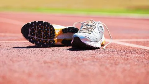Taking a break from the race. A pair of running shoes lying on a running track. Stock Photos