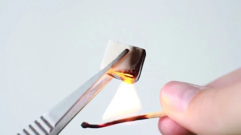 Taking burning sugar in tweezers Видео 77185197