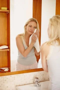 Taking care of her flawless complexion. A beautifl young woman drying her face Stock Photos