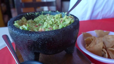Taking a chip and dipping into freshly made guacamole  Stock Footage 294892941