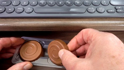 Taking chocolate biscuit from slide out computer desk. Stock Footage 114164823