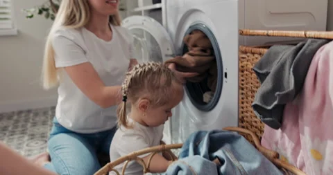 Taking clothes out of the wicker basket and putting them in the washing machine Видео 199904219