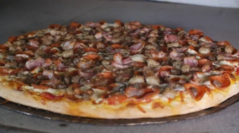 Taking Cooked Meat Lovers Pizza Out Of Hot Commercial Industrial Stone Oven Video stock 66107876