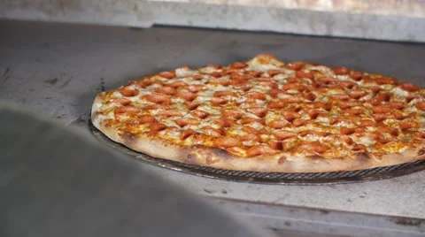 Taking Cooked Pepperoni Pizza Out Of Hot Commercial Industrial Stone Oven Video stock 66111484