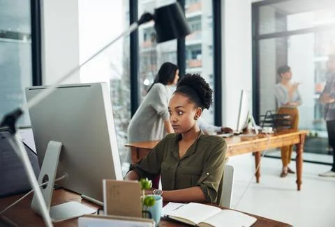 Taking the creative world by storm. a young businesswoman working on a computer Stock Photos
