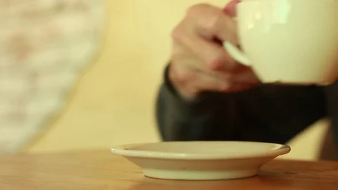 Taking a cup of tea and putting it back Stock Footage 73506848