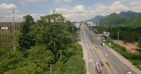 Taking off by drone over road with traffic next to mountains covered with forest Video stock 111302258