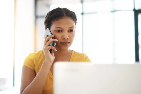 Taking on every work task with focus. a young businesswoman using a laptop and Stock Photos