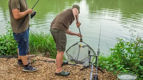 Taking a fish that they caught out of the water Stock Footage 112185034
