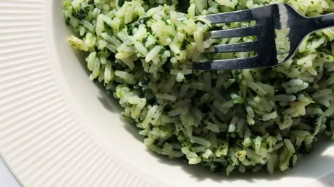 Taking a forkful of spinach rice dish Spanakorizo. Traditional Greek meal w.. Stock Footage 304326447