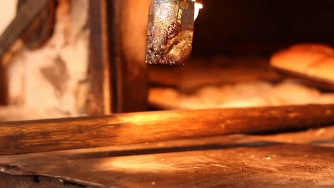 Taking fresh bread out of the oven Stock Footage 130084286