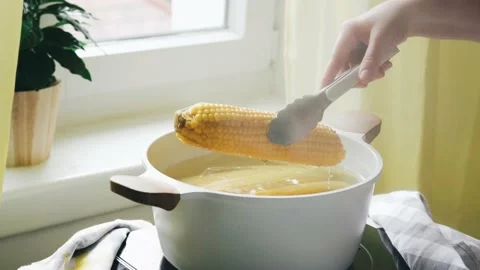 Taking fresh corn cob from pot with hot water 스톡 동영상 162569535