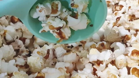 Taking fresh popcorn out with laddle. Video stock 159442340