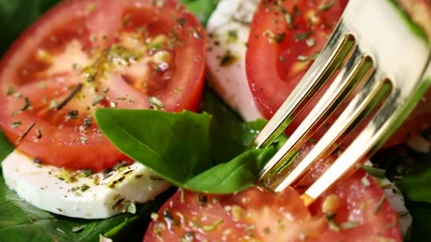 Taking fresh tomato, basil and mozzarella Caprese salad with a fork Stock Footage 277685055