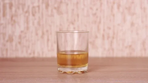 Taking a glass of whiskey Stock Footage 82521546