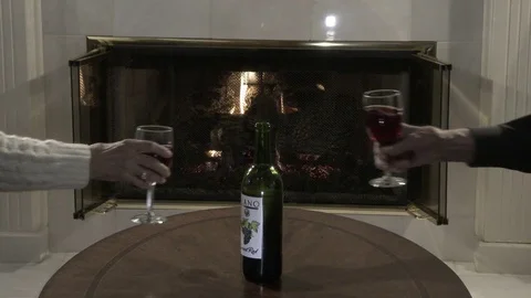 Taking a glass of wine in front of fireplace and clink the glasses, 4K. Stock Footage 84642809