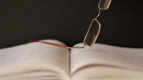 Taking glasses from a book Stock Footage 75628872