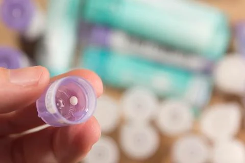 Taking granules of homeopathic medication Stock Photos